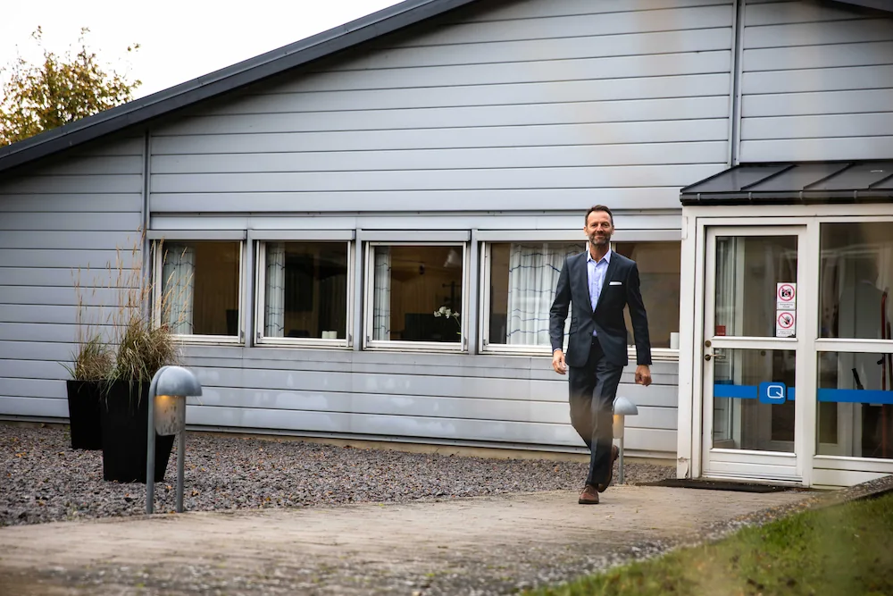 Q-Interline CEO Martin Roithner Henriksen press photo, walking from building at headquarters